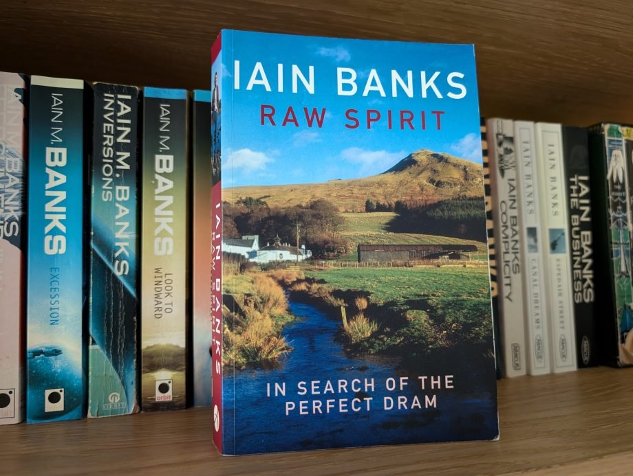 Raw Spirit by Iain Banks Raw Spirit by Iain Banks - the search for the perfect dram. A white whisky distillery building sits in the picturesque Scottish countryside under a blue sky.